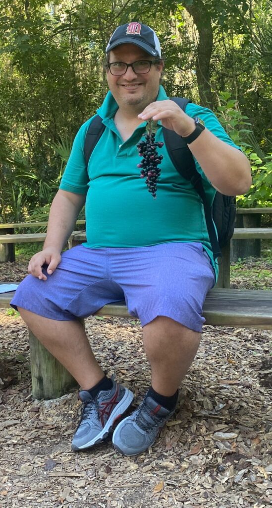 large man holding fake grapes at National Park in Jacksonville