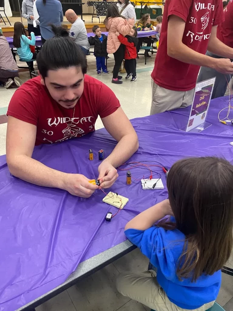 girl learning about robotics form a high school team building geek culture