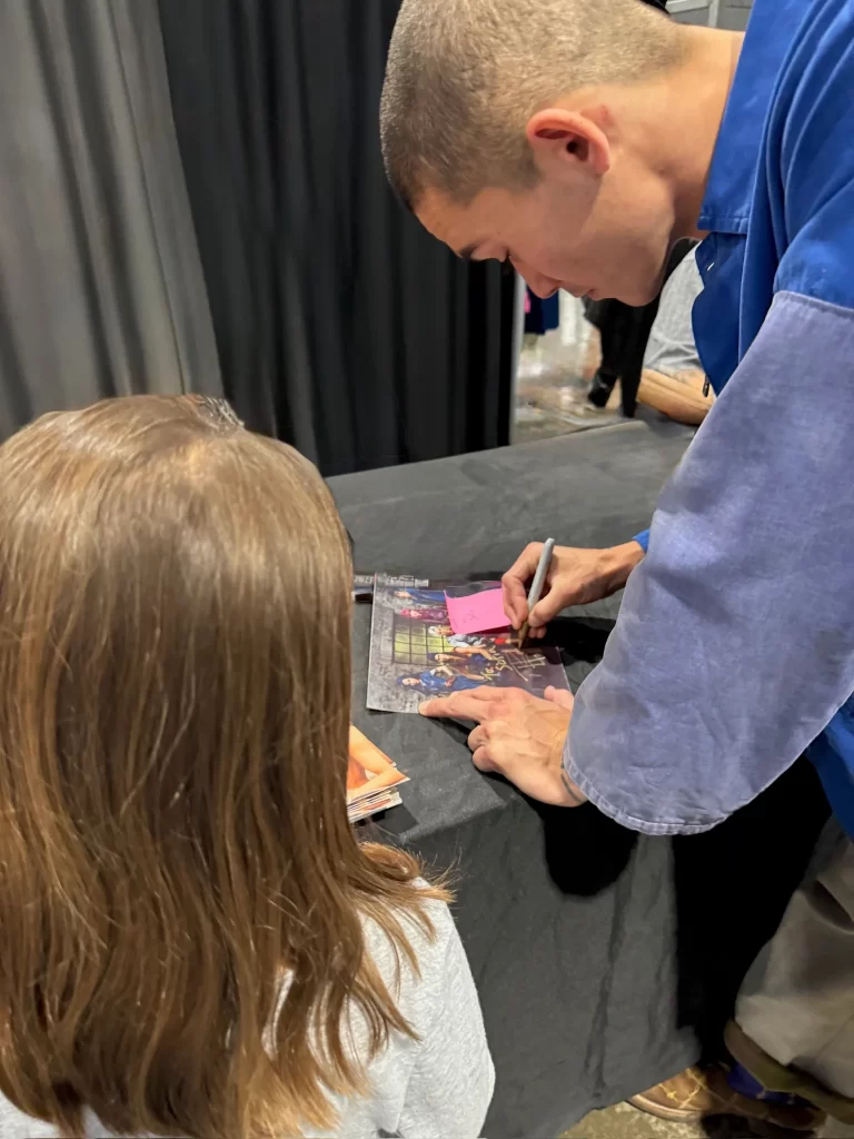 Gril Getting an Image Signed by Booboo Stewart at Mississippi Comic Con 2024